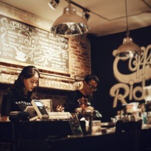 Baristas preparing coffee at Coffee Rider, Karawaci. Cozy indoor setting with menu board.