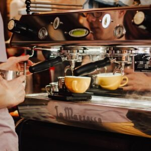 Bar Cafetería en Montanejos. Barista using espresso machine to brew coffee in a café, showcasing coffee preparation process.